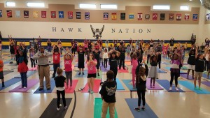 Students perform yoga in gym