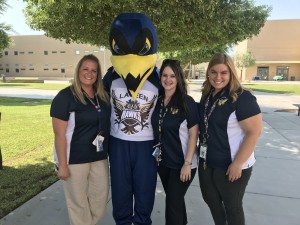 Staff members pose with school mascot